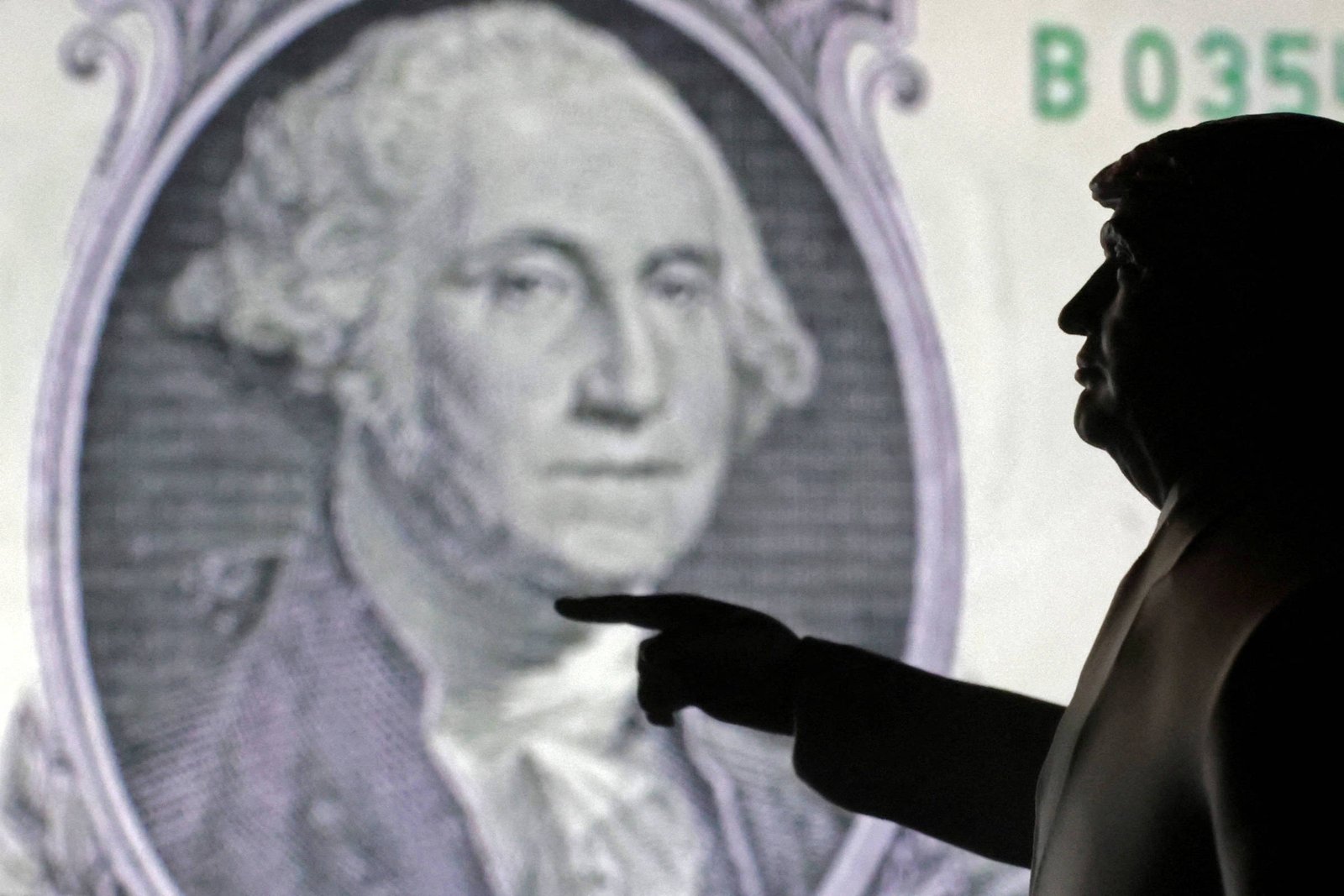 A imagem mostra a silhueta de uma figura humana em primeiro plano, apontando para uma imagem de George Washington que aparece em uma nota de um dólar ao fundo. A silhueta é escura, enquanto a nota de um dólar é iluminada, destacando o rosto de Washington.