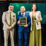 Diego Bastos Moraes recebe reconhecimento no palco da Confraria dos Palcos ao lado dos organizadores do evento