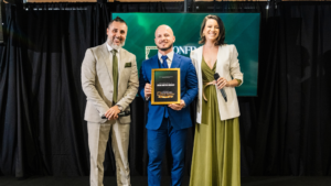 Diego Bastos Moraes recebe reconhecimento no palco da Confraria dos Palcos ao lado dos organizadores do evento