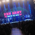 Palco da KNN Convention 2026 Born To Win com público lotado e equipe no palco durante encerramento do evento