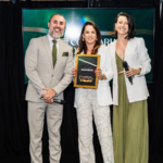 Mariléia Martins recebe reconhecimento durante participação na Confraria dos Palcos, ao lado de dois apresentadores em palco