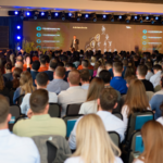 Palestrante no palco do Congresso RS diante de auditório lotado, com empresários e líderes assistindo apresentação sobre crescimento e gestão